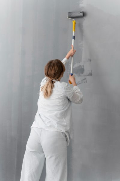 medium-shot-woman-painting-wall